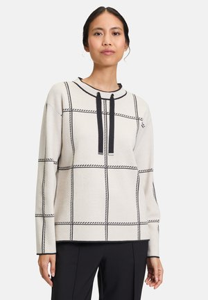 Beige pullover sweater with black grid pattern, featuring a rounded neckline and black drawstrings, made of a textured knit fabric.
