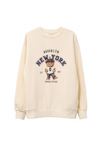 Sweatshirt crème avec un graphique d'ours portant une casquette de baseball, avec les textes "BROOKLYN" et "NEW-YORK" en bleu marine et rouge. Poignets et ourlet côtelés.
