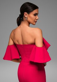 Abito aderente in tessuto rosa brillante con maniche a sbuffo off-the-shoulder e una zip sul retro. Texture liscia e silhouette definita.