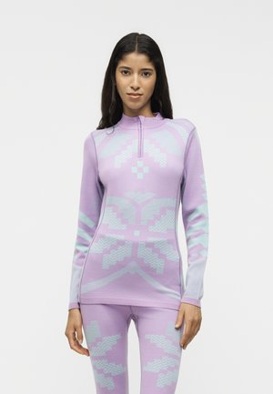 Femme portant une tenue de sport ajustée lavande avec un col montant zippé et des motifs géométriques abstraits bleu clair.