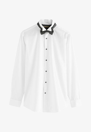 Witte shirt met lange mouwen, zwarte knopen en een zwarte vlinderdas om de kraag. Gladde stof, standaard ontwerp van een dress shirt.