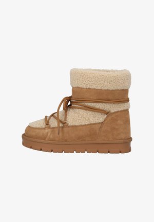 Stivale alla caviglia in suede marrone con fodera in shearling crema, caratterizzato da un design con lacci e una suola in gomma testurizzata per aderenza e durata.