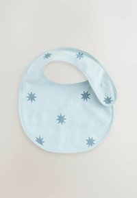 Bib de color azul claro, hecho de una tela suave, con un estampado de estrellas azules y un cierre a presión ajustable para un uso seguro. Textura suave y forma redondeada.
