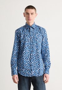 Chemise à manches longues à boutons de couleur bleu marine avec un motif floral en bleu clair et rose. Dotée d'un col pointu et de boutons à l'avant.
