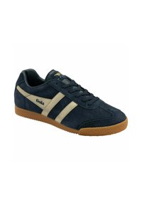 Sneaker scamosciato blu navy con strisce beige, presenta una suola in gomma e accenti testurizzati. Lacci fissati attraverso sei occhielli.