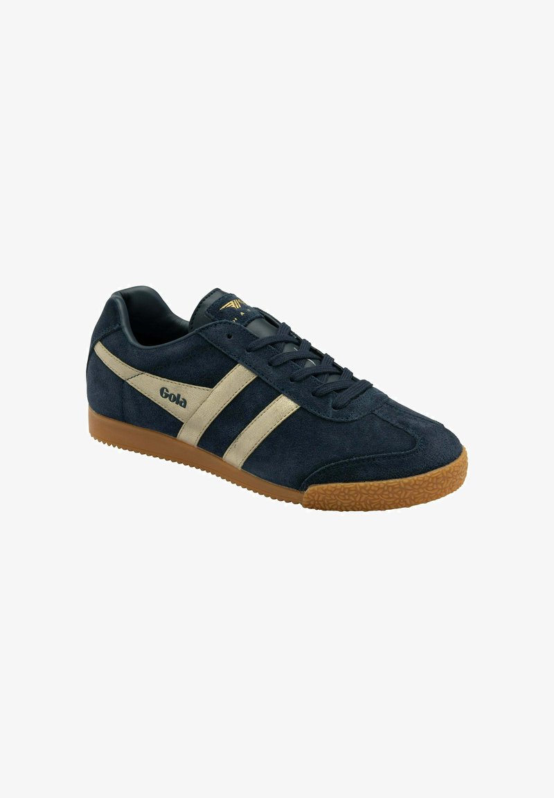 Sneaker scamosciato blu navy con strisce beige, presenta una suola in gomma e accenti testurizzati. Lacci fissati attraverso sei occhielli.