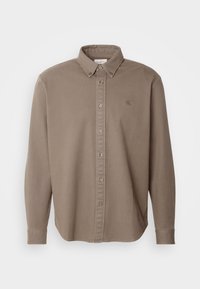 Langärmeliges taupefarbenes Hemd mit Knöpfen, Button-Down-Kragen, durchgehendem Knopfleiste und dezentem "CK"-Logo auf der linken Brust.