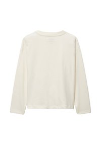 Chemise à manches longues en coton blanc cassé, avec un col rond et une coupe décontractée. Le dos présente un texte imprimé subtile près du col.