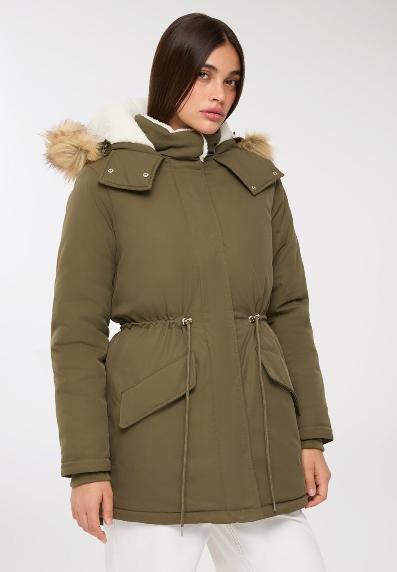 Oliwkowa kurtka parka wykonana z poliestru, z kapturem wyłożonym futrem, regulowanym sznurkiem w talii oraz dwoma przednimi kieszeniami.