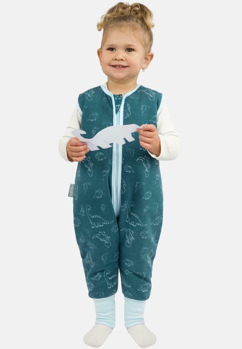 Türkisfarbener Baumwollstrampler mit Dinosaurier-Muster, Vorderreißverschluss und hellblauen Akzenten. Das Kind hält einen Papierschnitt eines Dinosauriers und trägt helle Socken.