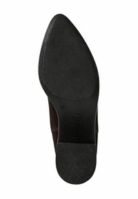 Semelle en caoutchouc texturé noir avec un léger contour, présentant une zone de bout lisse et une tige en daim marron foncé. Taille 37 marquée sur la semelle.