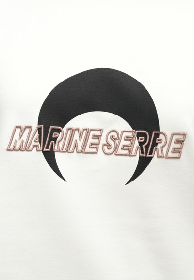 Balts sporta krekls ar lielu melnu pusmēness grafiku un rozā izšuvumu "MARINE SERRE", ar gludu un mīkstu tekstūru.