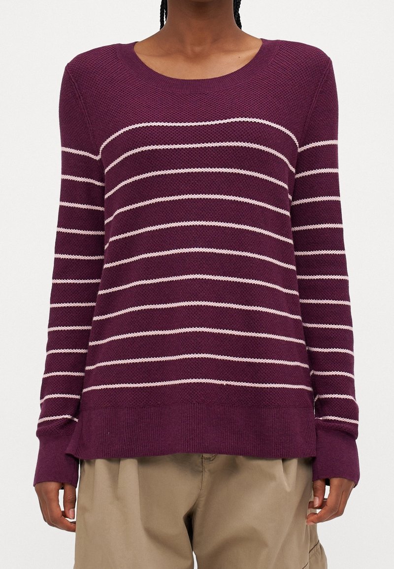 Lila stickad tröja med rosa horisontella ränder, rund halsringning, långa ärmar och ribbad nederkant. Mjuk textur och avslappnad passform.