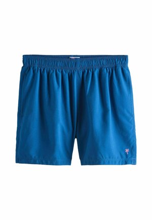Pantaloncini da nuoto blu con elastico in vita e piccolo logo di una palma rosa sulla parte inferiore della gamba sinistra, su sfondo bianco.