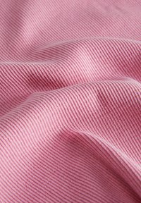 Rózsaszín bordázott anyag, amely lágy textúrával rendelkezik, keskeny függőleges csíkokkal és sima felülettel, finom hullámokban hajtogatva.