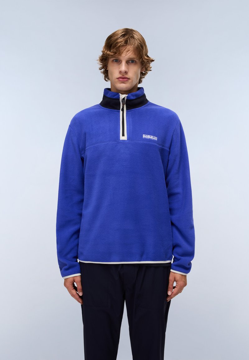 Blue fleece pullover with a high collar, quarter zip, and contrasting black neck, featuring a white horizontal stripe and logo.