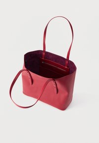 Κόκκινη δερμάτινη τσάντα ώμου με δύο λουριά, ανοιχτό πάνω μέρος και εσωτερική τσέπη με φερμουάρ, εμφανιζόμενη σε λευκό φόντο.