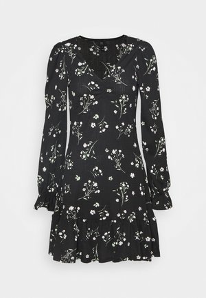 Schwarzes Kleid mit V-Ausschnitt, langen Puffärmeln und ausgestelltem Saum. Mit floralem Muster in Weiß- und Grüntönen auf strukturiertem Stoff.