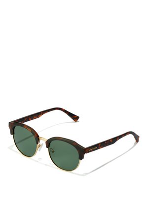 Ronde zonnebril met een schildpad-acetaat frame, groene gepolariseerde lenzen en gouden metalen accenten op de neuskussens en de pootjes.