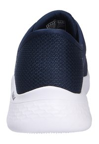 Chaussure de sport en maille bleu marine vue de dos, avec une semelle épaisse blanche texturée et une étiquette de taille visible à l'intérieur du talon.