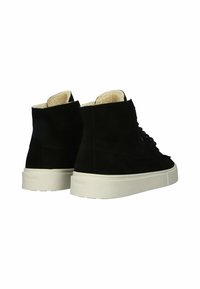 Zapatillas altas de ante negro con suela de goma blanca y un interior forrado de suave acolchado. Cuentan con cordones negros y una marca simple en el talón.