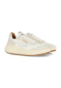 Zapatillas beige y blancas con una suela de goma texturizada, paneles de cuero y ante, detalles perforados y un logo en la lengüeta.