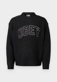 Pulover negru tricotat cu guler rotund, având „OBEY” brodat alb pe piept. Model texturat pe întreaga suprafață.