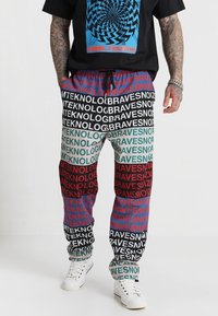 Mehrfarbige Jogginghosen mit auffälligen Textmustern in Rot, Grün, Blau und Schwarz. Aus leichtem Stoff mit einem elastischen Bund gefertigt.