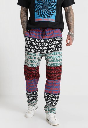 Multicolored jogger pants featuring bold text patterns in red, green, blue, and black. Made of lightweight fabric with an elastic waistband.