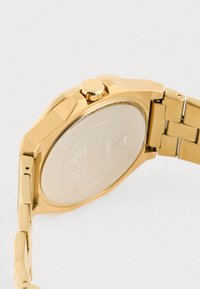 Orologio in acciaio inossidabile dorato con cassa ottagonale, finitura liscia e bracciale a maglie. Presenta una corona texture e un fondello di cassa silver.