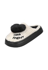 Zapatilla de felpa blanca con un pompón negro y la palabra "ORNAMENT" bordada. Presenta una parte superior texturizada y una suela de goma negra.