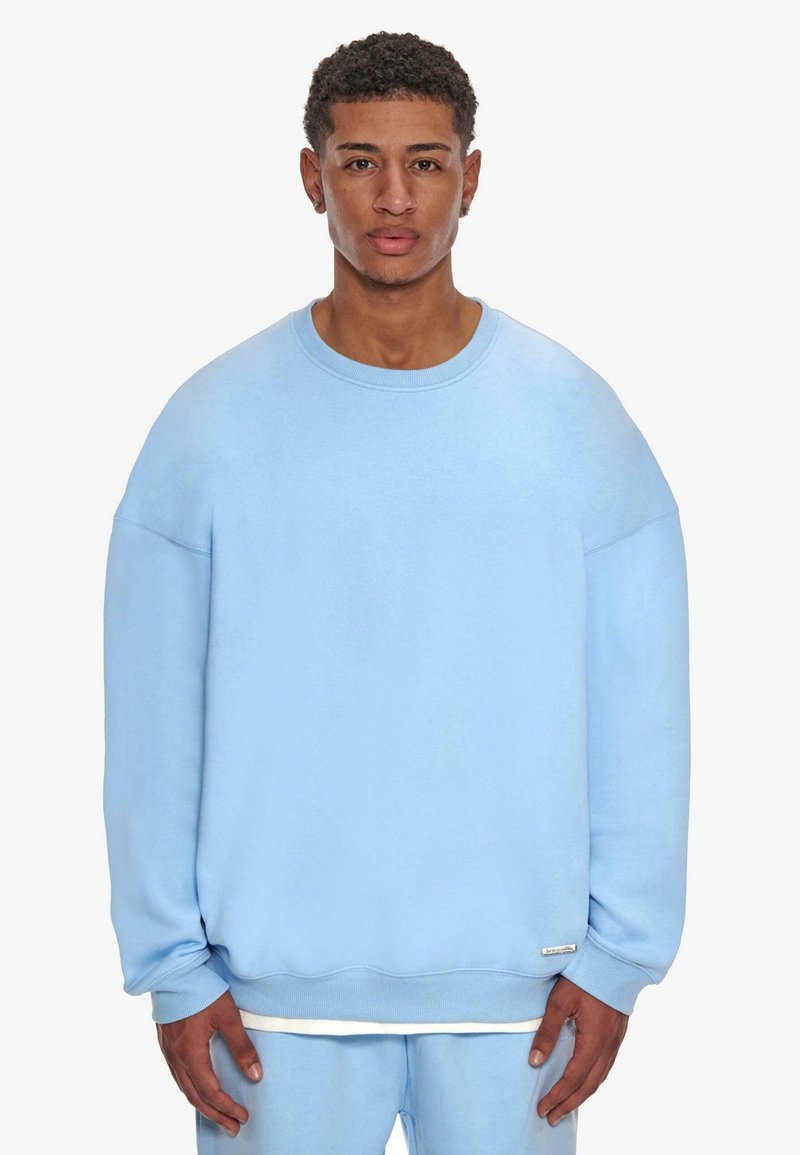 Lichtblauwe sweatshirt van zachte stof, met een relaxte pasvorm, wijde mouwen en ribgebreide manchetten. Inclusief een klein logo-label aan de onderkant.