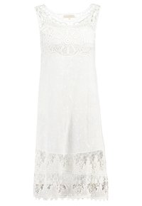 Robe blanche sans manches en dentelle avec motifs floraux, détail en dentelle circulaire sur la poitrine et ourlet en dentelle transparente.
