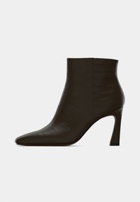 Brune høye hæler ankelsko i krokodilleprøvd lær, med spiss tå og stiletthæl, som har en glatt tekstur og slank profil.