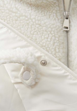 Weiße Fleece-Beschichtete Jacke mit glattem Äußeren, silbernem Reißverschluss und Druckknopfdetails. Verfügt über ein weiches, strukturiertes Innenfutter.
