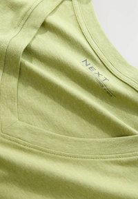 Lichtgroen, slouchy V-hals T-shirt van zacht katoen. Beschikt over een textuurafwerking en een label met "NEXT" branding.