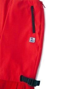 Pantaloni scurți sport roșii realizați dintr-un material neted. Prezintă un buzunar lateral cu margine neagră și o cataramă reglabilă neagră pe talie. Include o insignă cu logo.