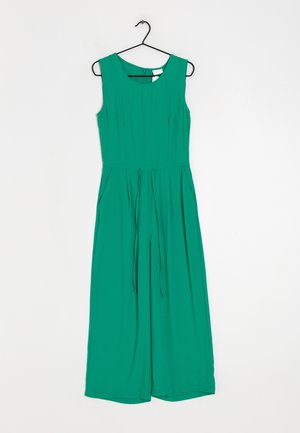 Zielony bezrękawnikowy kombinezon z dopasowaną górą, szerokimi nogawkami, bocznymi kieszeniami i detalem wiązania w talii. Wykonany z gładkiego, lekkiego materiału.