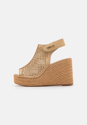 Sandales compensées en suedé beige perforé avec une semelle plateforme en jute, dotées d'une bride arrière et d'un accent métallique avec le logo.