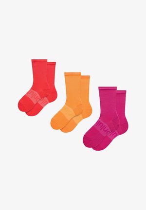 Tre par mandsstrømper i rød, orange og pink, hvert par stablet med en sok, der overlapper den anden let.