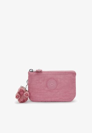 Cartera de nylon rosa con un acabado texturizado, cierre de cremallera y parches de logo circular. Presenta un llavero de monito peludo adjunto.