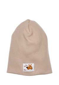 Beige neulepipo, jossa on ribbimäinen rakenne ja pieni valkoinen merkki, jossa on sarjakuvakoira ja teksti "How How How". Pehmeä ja joustava materiaali.