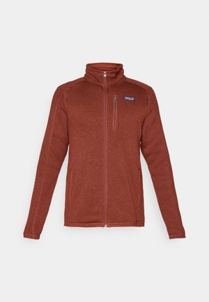 Roestkleurige volledige rits fleecejack met staande kraag, borstzak met rits en twee zijzakken, Patagonia-logo op de linkerborst.
