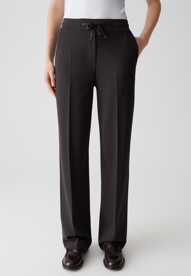 Pantaloni neri a gamba larga con vita regolabile. Realizzati in tessuto liscio e testurizzato; presentano pinces anteriori e tasche laterali.