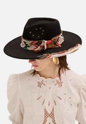 Chapeau en feutre noir à large bord avec un bandeau tissé multicolore comportant un bord à franges et de subtils accents brodés sur la couronne.