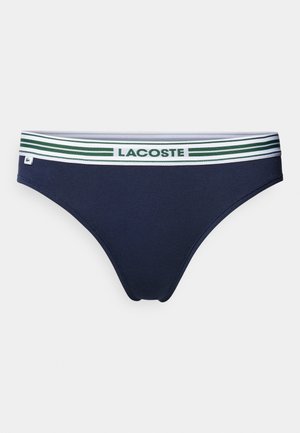 Navy blue brief with a soft, stretchy fabric. Features a white elastic waistband with green stripes and "LACOSTE" logo in the center.