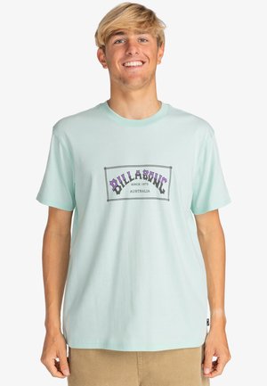 Light green cotton t-shirt featuring a graphic print in purple and black with text, crew neck, and short sleeves.