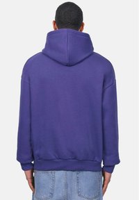 Purple hoodie made of cotton blend, featuring a drawstring hood, ribbed cuffs, and hem, with a relaxed fit and no visible logos or patterns.