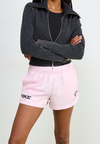 Černá kordurová bunda na zip, přiléhavá, doplněná o světle růžové šortky s elastickým páskem a černými logovými detaily.