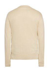 Beige színű, hosszúujjú pulóver sima, puha textúrával. Egyszerű, kerek nyakkivágással és bordás mandzsettákkal, valamint aljjal rendelkezik. Nincsenek látható logók vagy minták.